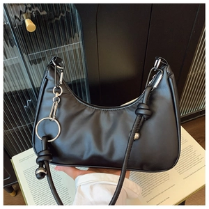 Détail d'un sac hobo en cuir PU noir avec anneaux métalliques argentés et nœuds décoratifs