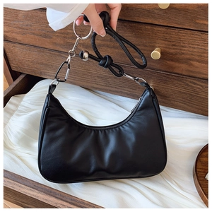 Détail du sac d'épaule demi-lune noir avec anneaux métalliques et sangle en cuir nouée