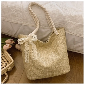 Detailed straw handbag weave with thick rope handles and delicate lace bow decoration