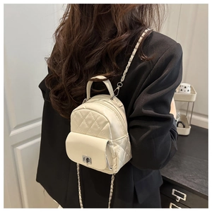Detailed back view of a mini quilted backpack with chain straps on a model