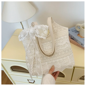 Detail of white lace handbag with multi-layer floral ruffles and large bow decoration