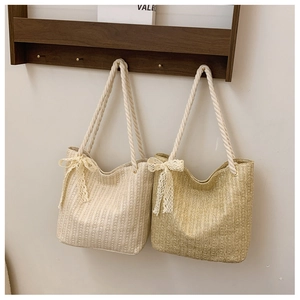 Close-up of woven straw tote bags featuring thick cotton rope handles and lace bow details