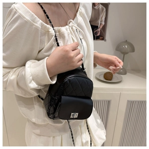 Detail of mini quilted backpack with silver twist-lock and chain strap on model