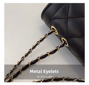 Close-up of gold metal grommet and leather chain strap on black quilted crossbody bag