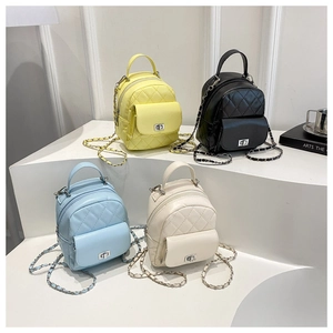 Close-up of mini quilted backpacks in yellow, black, blue and white on display
