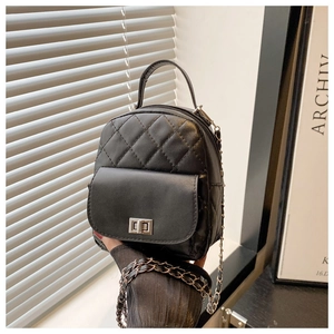 Close-up of a mini quilted black backpack with silver chain straps and metal twist lock