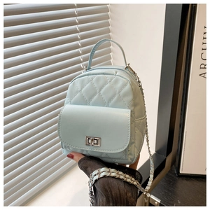 Close-up of light blue quilted mini backpack featuring silver twist-lock and chain strap
