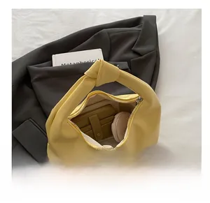 Close-up of yellow soft leather dumpling bag showing inner storage with matching coin purse