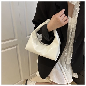 Close-up of a white patent leather crescent hobo bag with a silver zipper for women