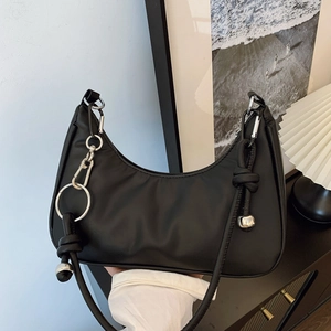 Minimalist black crescent shoulder bag with silver rings and decorative beaded knot strap