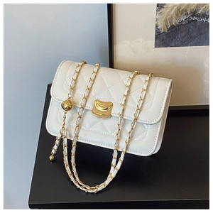 Detail of white quilted leather texture with gold metal clasp and chain strap adjustment