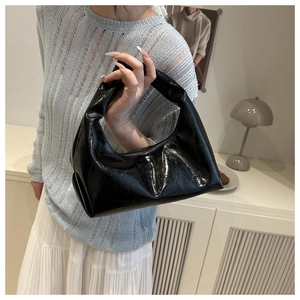 Detailed view of the black glossy hobo bag with a minimalist knotted handle design