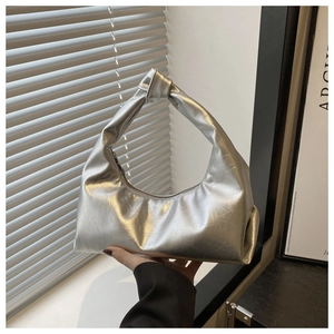 Close-up of metallic silver hobo bag featuring soft texture and decorative handle knot