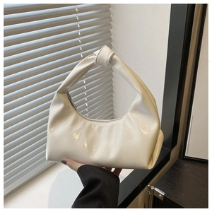 Detail of white glossy oil wax dumpling bag featuring unique knot handle and silver zipper