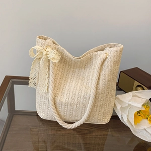 Chic beige straw woven tote bag with rope handles and lace bow for beach holidays