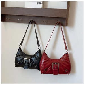 Detail view of vintage pleats and metal buckle on black and dark red leather shoulder bags