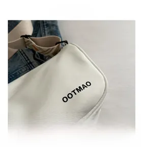 Detailed macro view of white canvas texture with black lettering and woven shoulder strap