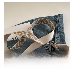 Detail of adjustable woven wide shoulder strap with geometric diamond patterns and metal clasp