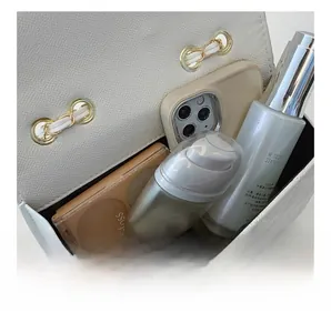 Top view of white mini crossbody bag interior showing spacious storage for smartphone and makeup