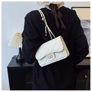 Detail of white quilted leather mini bag featuring gold chain and adjustable bead