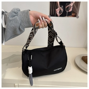 Close-up of black Boston bag with ethnic geometric strap and OOTMAO logo detail