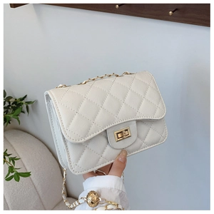 Close-up of cream quilted crossbody bag with golden twist lock and chain strap