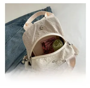 Detail view of beige nylon backpack capacity showing stored items and metal clasp