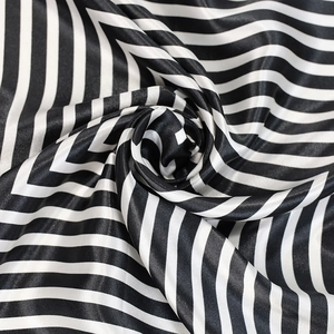 Close-up of elegant black and white striped satin silk scarf fabric in spiral folds