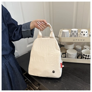 Gros plan du sac fourre-tout en nylon blanc cassé avec étiquette FASHION rouge et logo