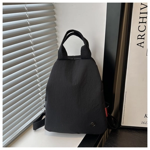 Détail du sac à dos en nylon noir imperméable avec poignées et étiquettes de mode