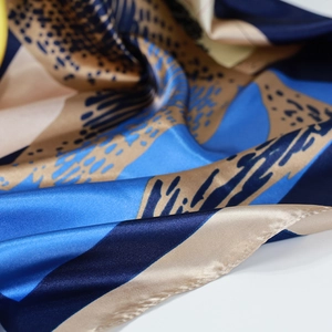 Seidiges quadratisches Halstuch mit blau-goldenen geometrischen Mustern und Pferdeprint