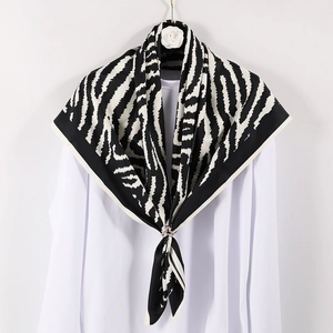 Elegant zebra print silk square scarf with animal pattern on a camellia hanger