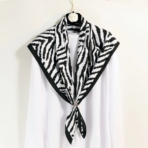 Elegant black and white zebra pattern silk scarf with a metal ring buckle on white clothing