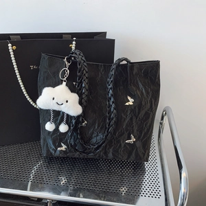 Large black pleated tote bag with silver butterfly charm and white plush cloud pendant