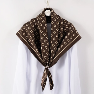 Brown silk-like square scarf with gold geometric letter print displayed on white clothing