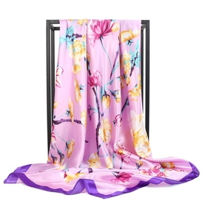 Pink floral satin square scarf with dark purple edges on a minimalist black metal frame