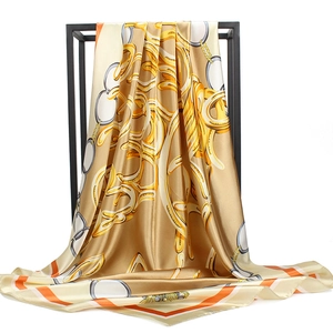 Detailed view of champagne satin scarf with golden chain patterns and striped edges