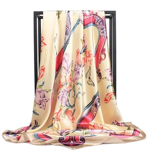 Elegant floral satin scarf draped on a black frame showing silk texture and drape