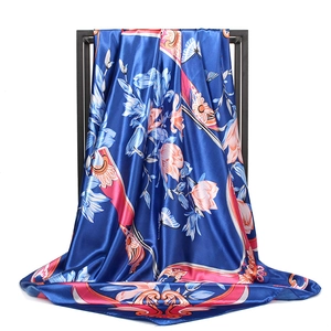 Deep blue satin square scarf with pink orange flowers and butterflies on a black metal rack