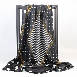 Gros plan d'un foulard élégant en satin noir et blanc avec motifs de chaînes dorées
