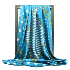 Carré en satin bleu roi à pois et motif de chaîne dorée sur un présentoir