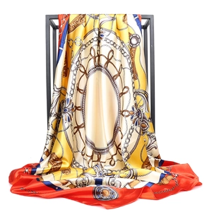 Detail of luxury satin silk scarf featuring equestrian chain prints and red border