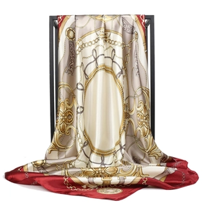 Detail of baroque silk scarf with golden chain print and elegant satin texture