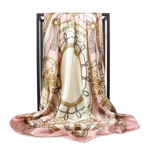 Close-up of pink chain print satin silk scarf draped over a black metal hanger