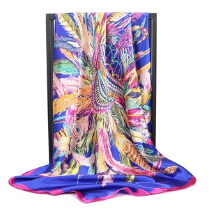 Detail of silk satin scarf with colorful feather patterns and royal blue background