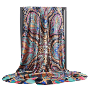 Détail macro du foulard en satin de soie avec motifs cachemire colorés et texture soyeuse