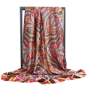 Vue détaillée d'un foulard en satin de soie coloré avec motif paisley sur support