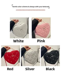 Detail view of heart-shaped quilted bags with pearl handles and bow in five colors