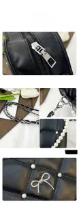 Detail of black quilted leather handbag with silver bow hardware and pearl strap