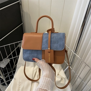 Crossbodytas met contrastpanelen in bruin leer en blauwe denim met handvat